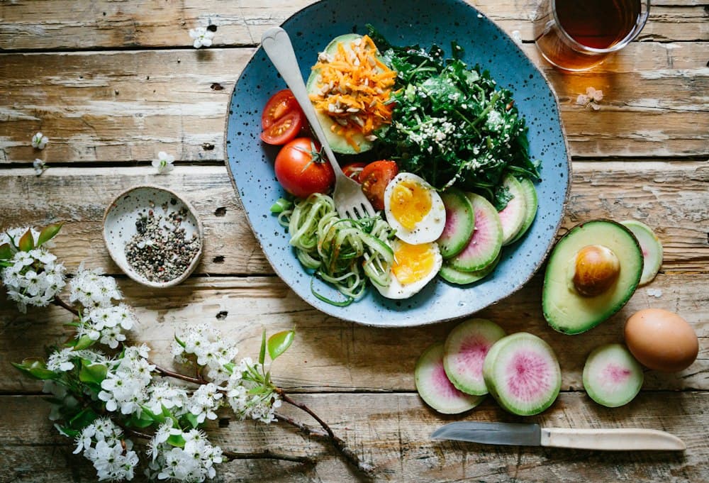 Healthy food plate with eggs, greens and avocado for nutrition coaching
